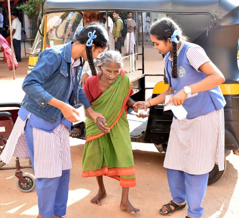 Photo of an elderly voter receiving assistance at a polling booth