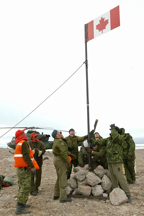 Canadian military personnel landing on Hans Island and raising the Canadian flag
