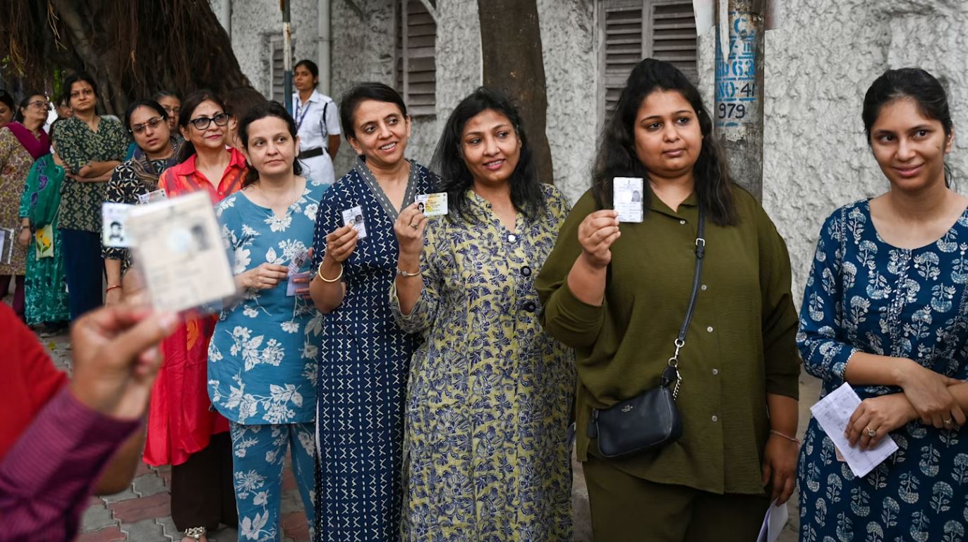 Photo of women queuing outside a rural polling booth