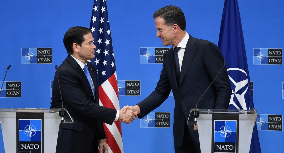 NATO Secretary General Mark Rutte shakes hands with US Secretary of State Marco Rubio during a NATO press conference amid debates over European defense dependence and increased US troop deployments in Europe.